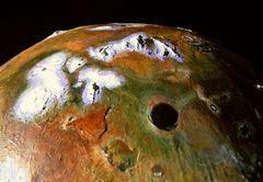 Dazhbog Patera (black pit) and arctic Vivasvant Mts (lavender & white) on Io. Click to enlarge
