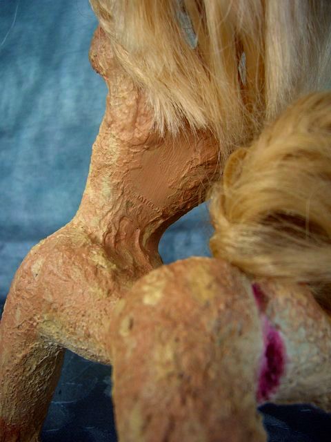 Mattel trademark still visible on back of a Kakalean native--a centaur made of fused Barbies. Click to enlarge.