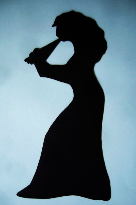 silhouette of woman playing pan-pipes