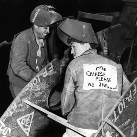 WW2 shipworker with sign on his back: 'ME CHINESE PLEASE NO JAP'.