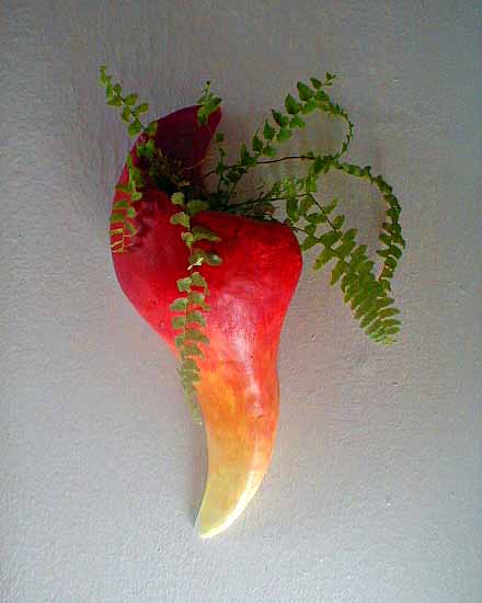 Photo of a red plant-sconce shaped like a stylized flame.