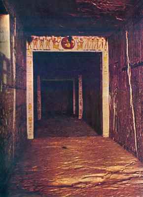 Photo of the entrance to the tomb of Pharaoh Rameses III. Squarish post-and-lintel stone doorways decorated with hieroglyphs lead down a hall into darkness.