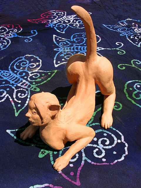 Crouching sphinx with raised tail; unfired clay sculpture.  Click to enlarge.
