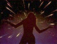 Night sky. Silhouette of a woman raising arms in wonder at a spectacular meteor shower.