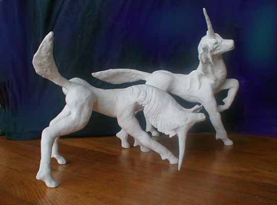 Two unicorns playing: unpainted sculptures.