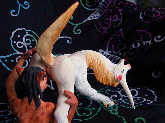 Coyote satyr licking a unicorn mare: painted sculpture. Click to enlarge.