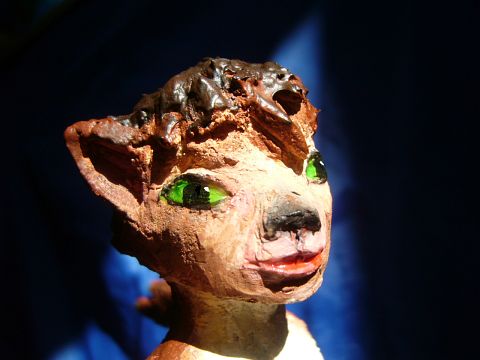 Sculpture of a dream by Chris Wayan: face of a green-eyed wolf dancer (head 4 cm tall). Click to enlarge.