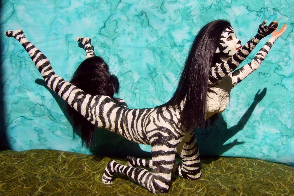 Sculpture, 'Suplica', by Chris Wayan: two Barbies fused into a zebra-striped centauroid dancer on her foreknees, arms and eyes raised.